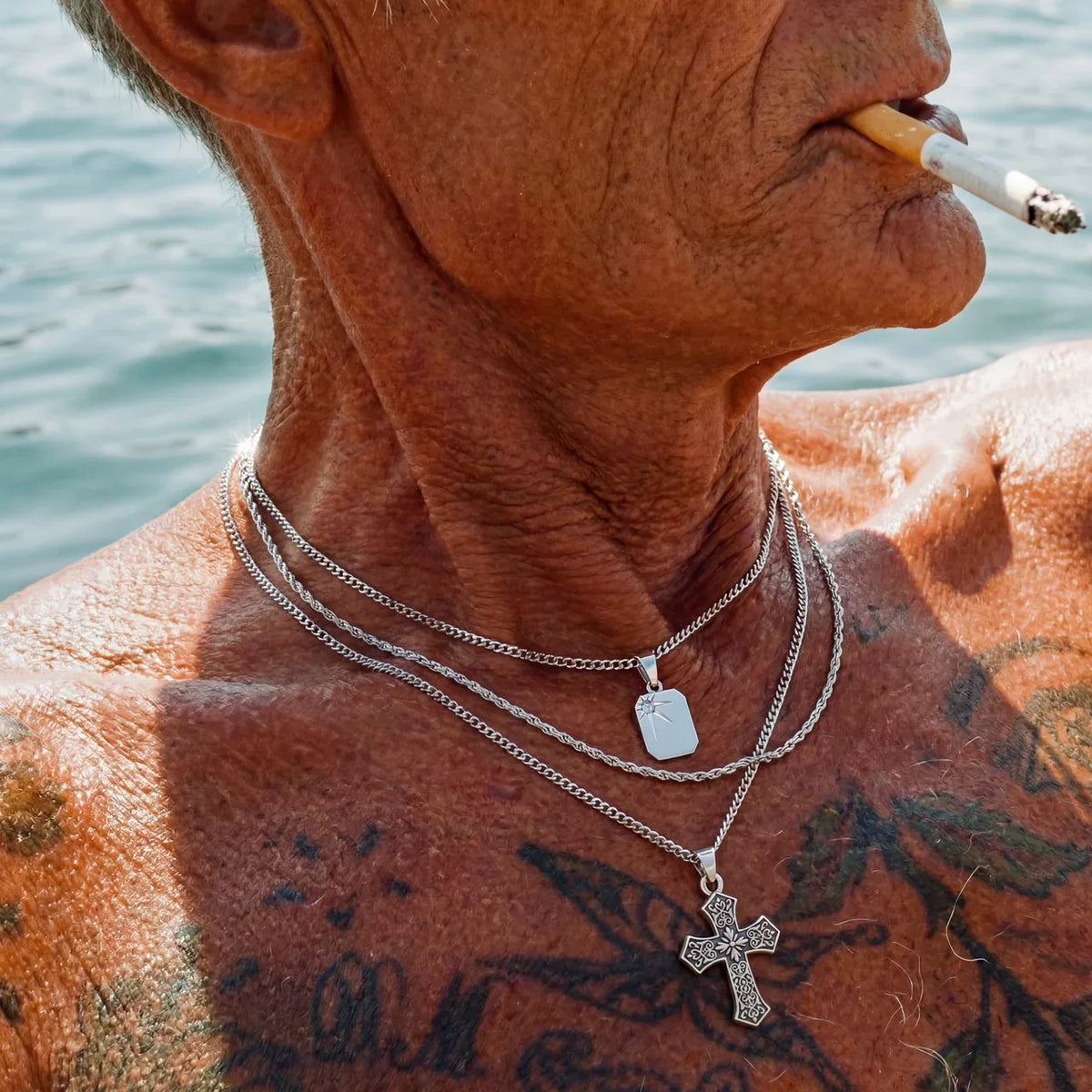 silver dog tag and cross chains layered men